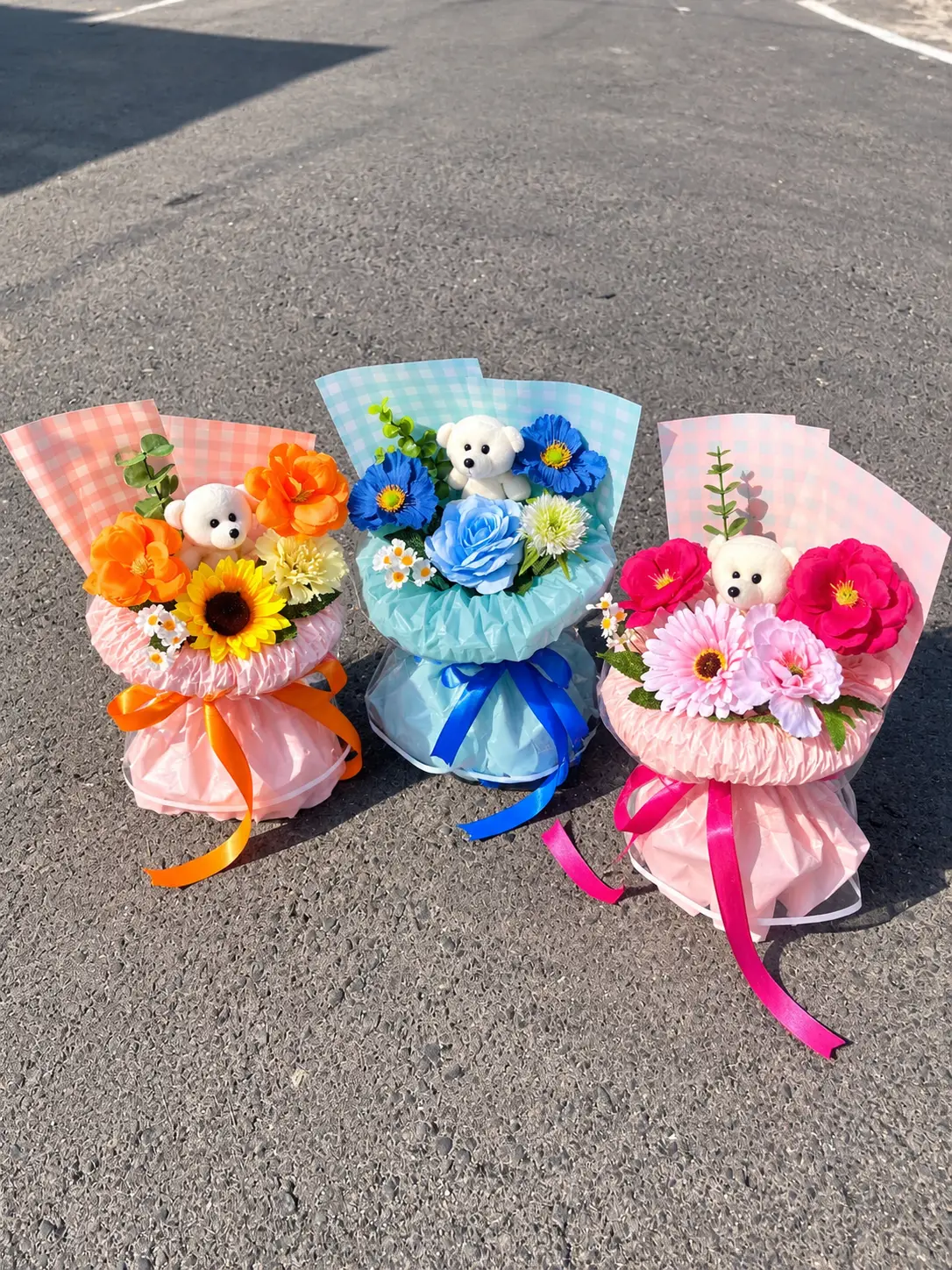 Buket mini Ajisai.flo dengan boneka beruang di tengah rangkaian.