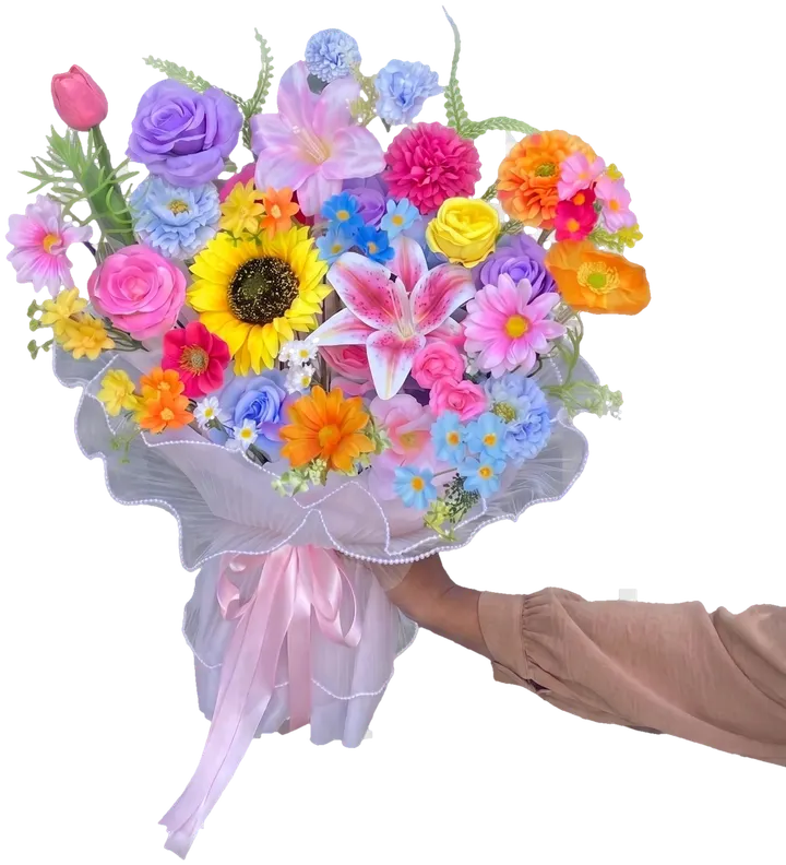 Buket bunga artificial Ajisai.flo berisi mawar, lily, bunga matahari, dan daisy warna-warni, dibungkus kertas organza putih dengan pita merah muda
